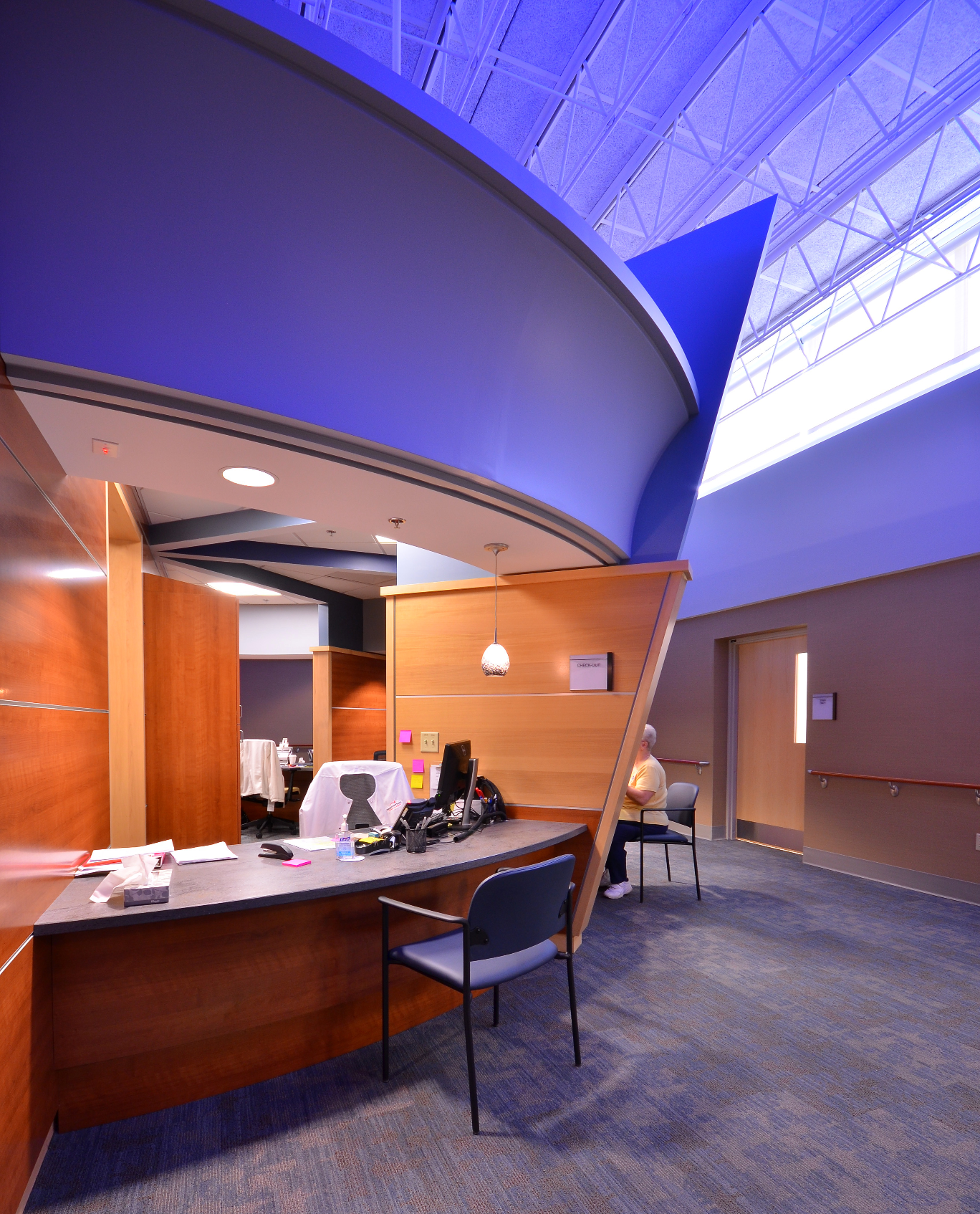 Healthcare reception with a sweeping blue skylit ceiling