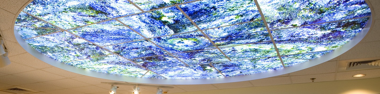 Backlit art-glass ceiling detail in a healthcare space