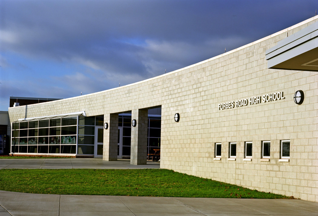 Stone-clad high school exterior at dusk